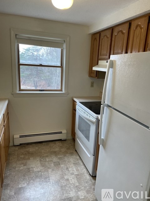 A kitchen with a white refrigerator and a window.