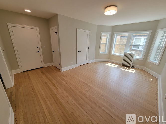A room with wooden flooring and white walls.