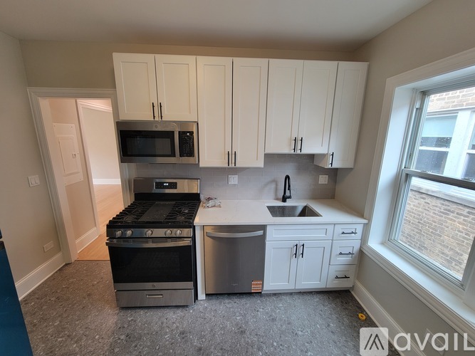 A kitchen with white cabinets and a stainless steel dishwasher.