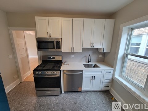 A kitchen with white cabinets and a stainless steel dishwasher.