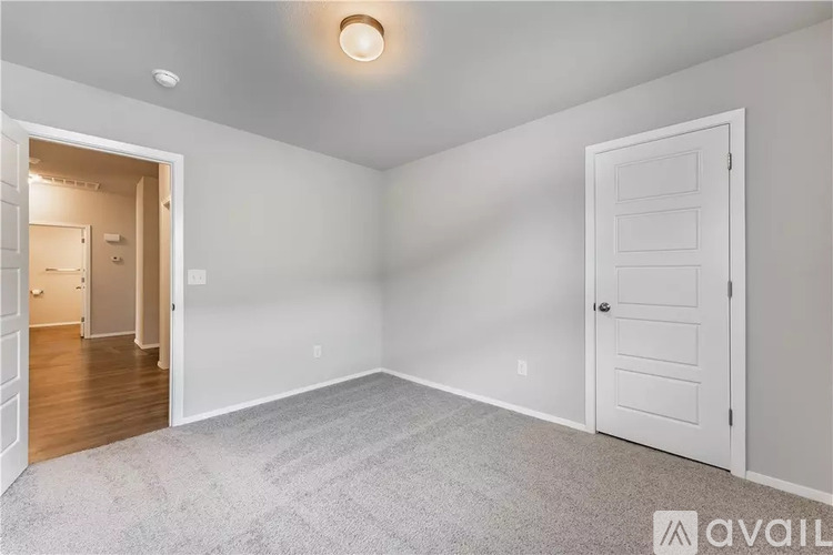 A room with a carpeted floor and a white door.