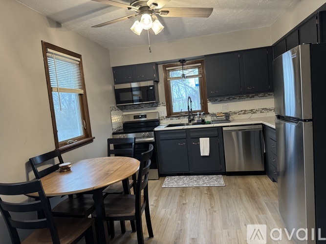 A kitchen with a table and chairs and a fridge.
