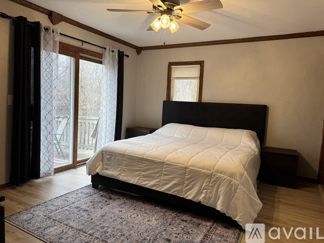 A bedroom with a large bed and a ceiling fan.
