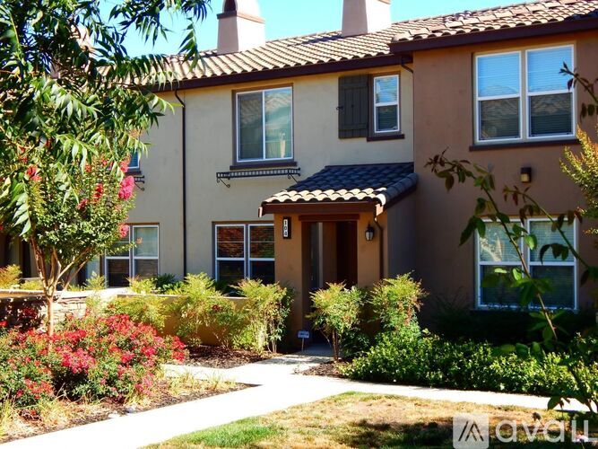 A house with a brown roof and a garden in front.