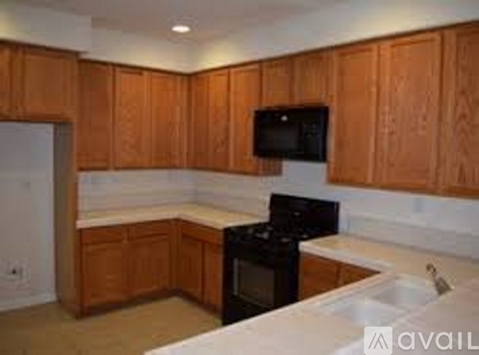 A kitchen with wooden cabinets and a black stove top oven.