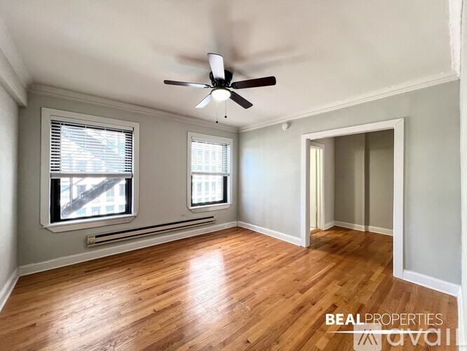 A room with a ceiling fan and wooden flooring.