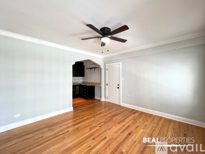 A room with a ceiling fan and wooden flooring.
