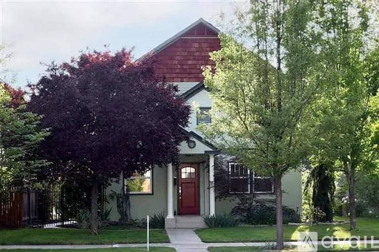 A house with a red door and a green lawn.