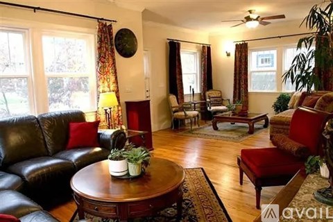 A living room with a black leather couch and a wooden coffee table.