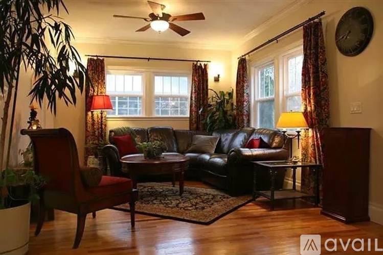 A living room with a red chair and a black couch.