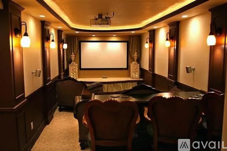 A home theater with a screen, chairs, and a carpeted floor.