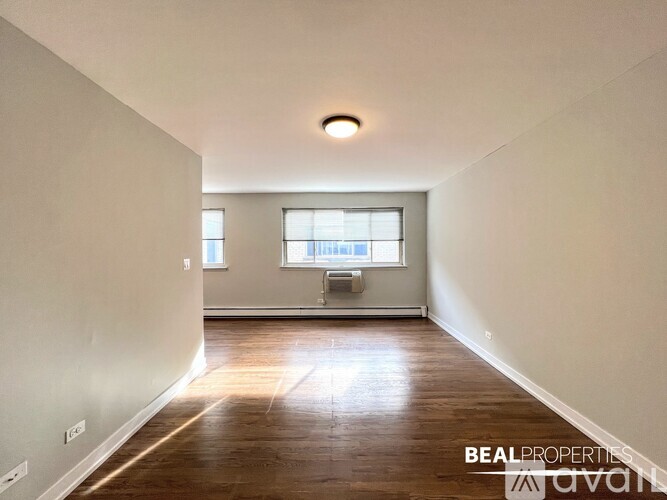 A spacious room with wooden floors and a window.