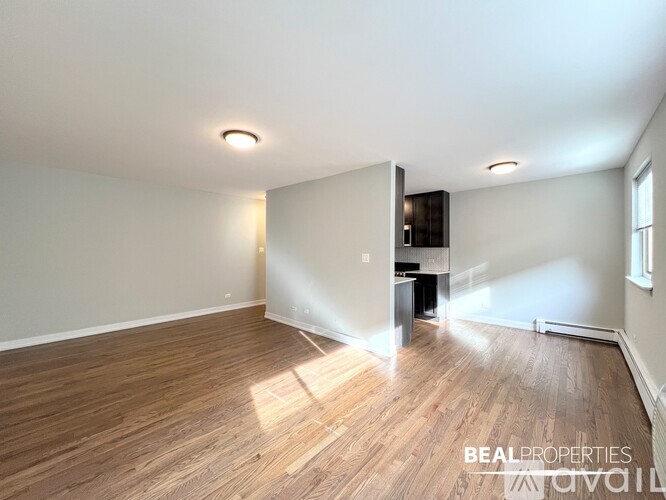 A spacious room with wooden flooring and a flat-screen TV mounted on the wall.
