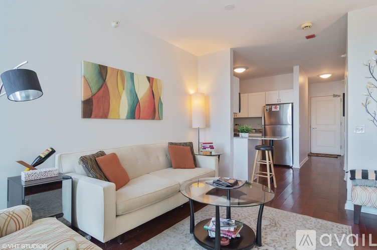 A living room with a white couch and a painting on the wall.