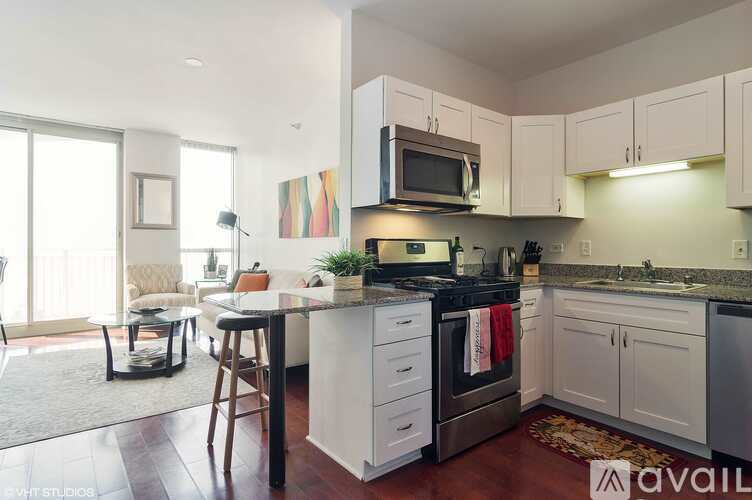 A kitchen with white cabinets and a black stove top oven.