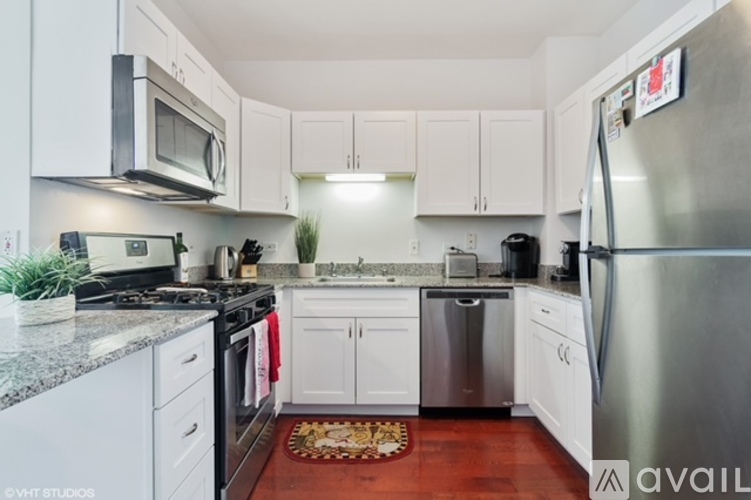 A kitchen with white cabinets and a stainless steel refrigerator.