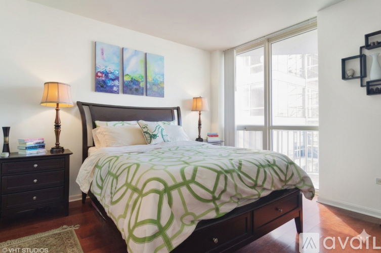 A bedroom with a large bed and two lamps on either side.