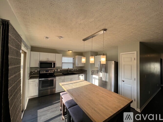 A kitchen with a wooden table and chairs, and a modern design.
