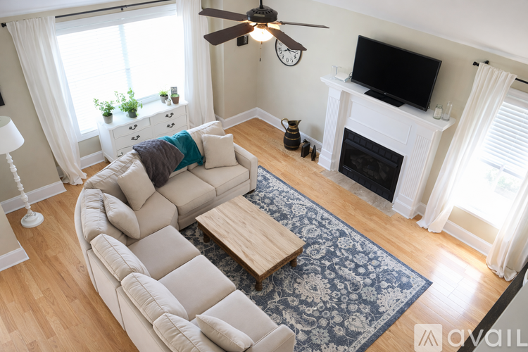 A living room with a white couch and a fireplace.