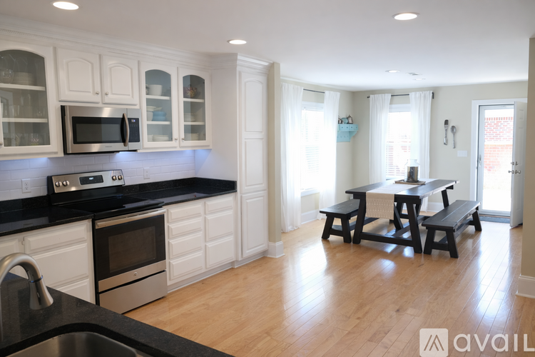 A kitchen with white cabinets and a black countertop.