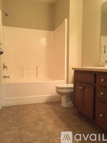 A bathroom with a toilet, a bathtub, and a cabinet.