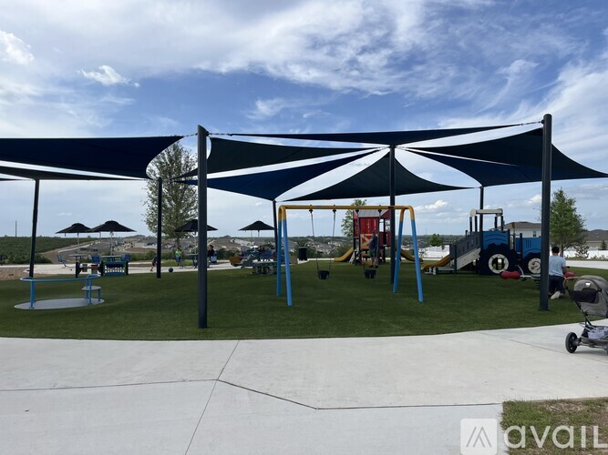 A playground with a blue canopy and a slide.