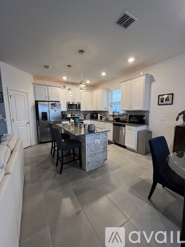 A kitchen with a table and chairs in the middle of the room.