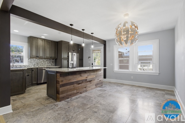 A modern kitchen with a wooden counter and a chandelier hanging from the ceiling.