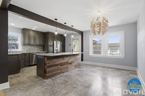 A modern kitchen with a wooden counter and a chandelier hanging from the ceiling.