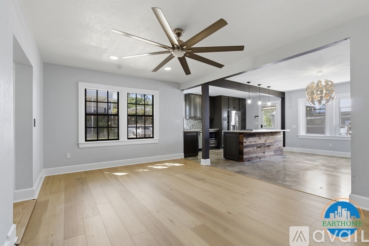 A spacious room with a ceiling fan and wooden flooring.