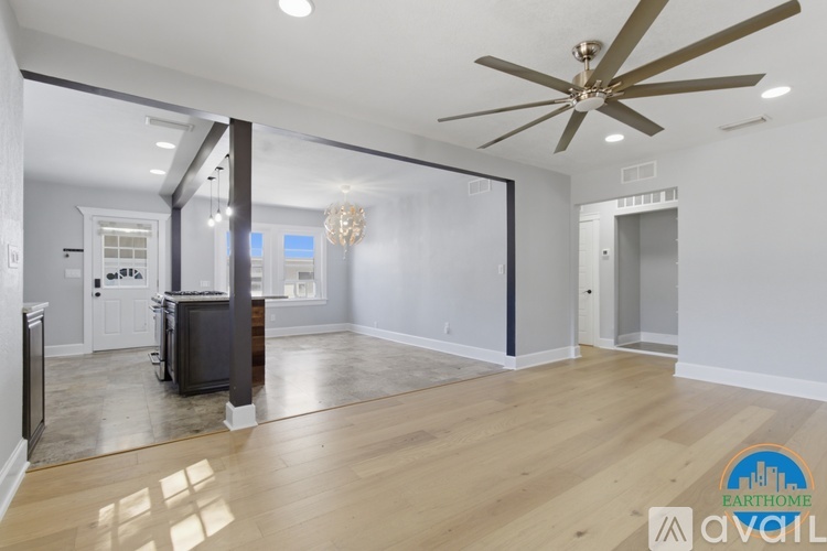 A spacious living room with a ceiling fan and hardwood floors.
