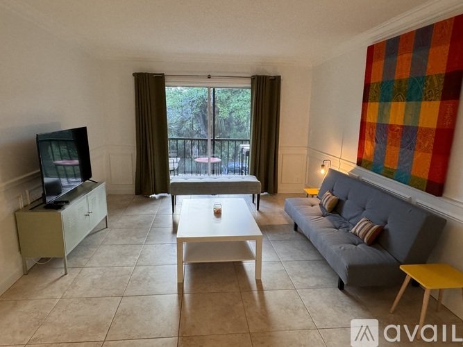 A living room with a television, sofa, and coffee table.