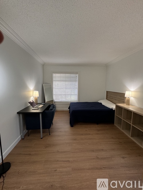 A bedroom with a bed, desk, and chair.
