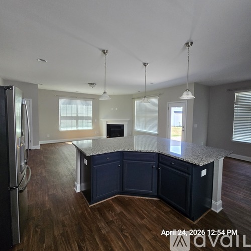 A kitchen with dark blue cabinets and a granite countertop.
