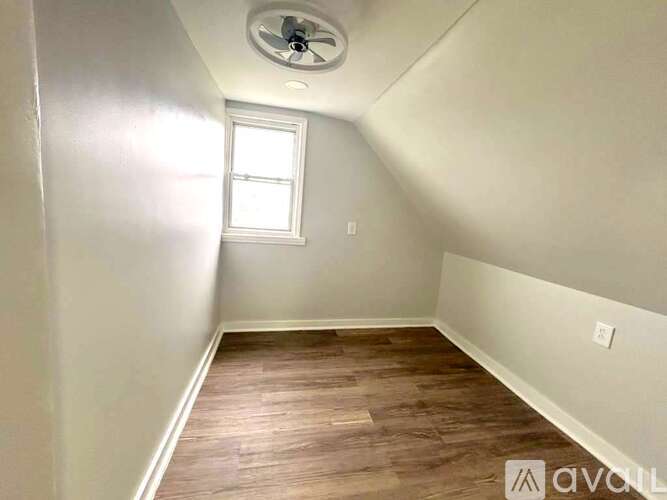 A room with a ceiling fan and a window.