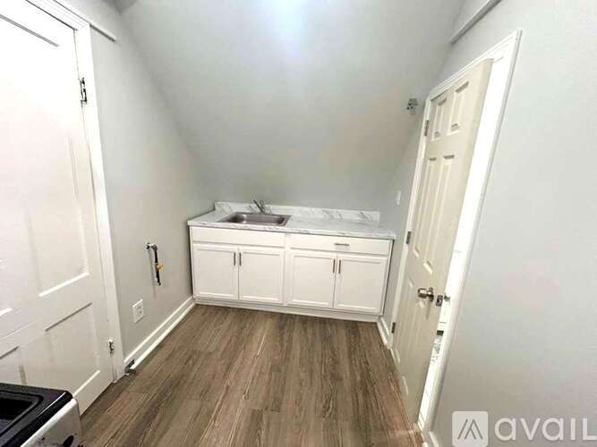 A bedroom with a bed, dresser, and cupboard.