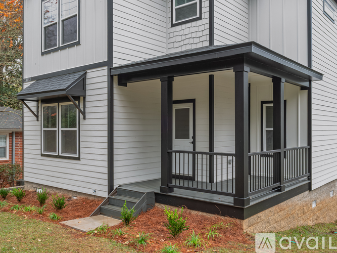 A house with a grey siding and a black porch.