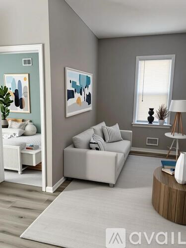 A living room with a grey couch and a white side table.