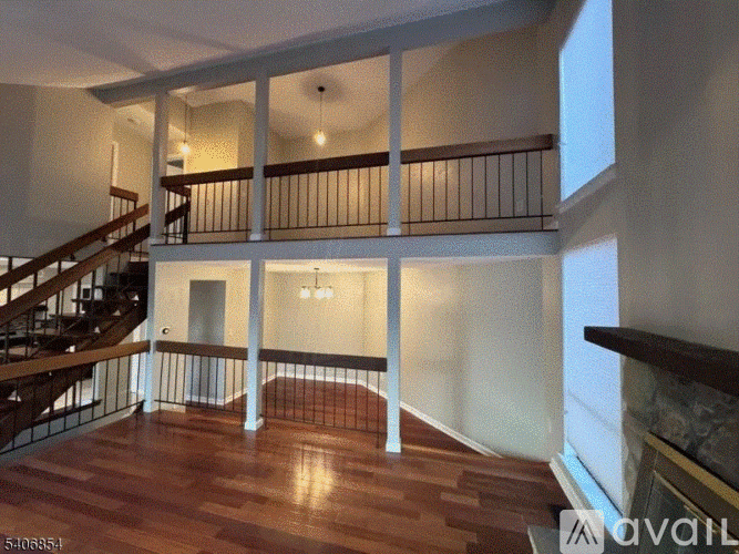 A large open living space with a staircase and a fireplace.
