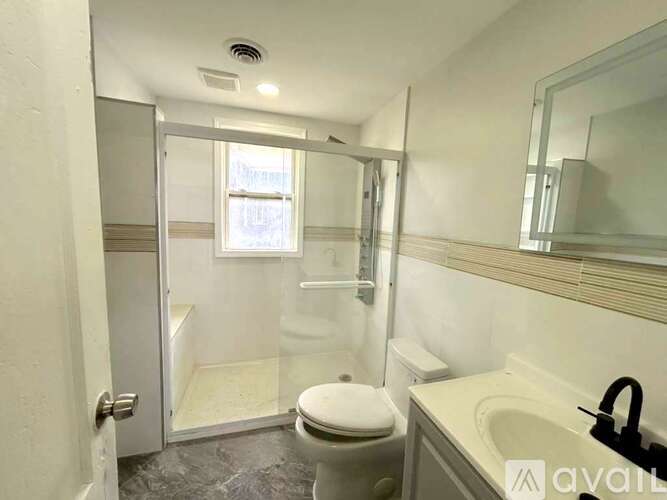 A bathroom with a toilet, sink, and shower.