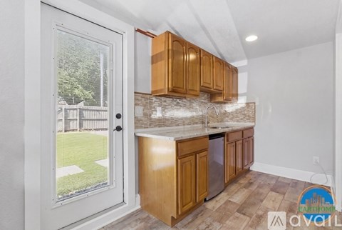 A kitchen with wooden cabinets and a marble backsplash is available for rent.