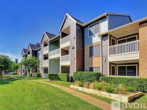 A row of modern apartment buildings with balconies and green lawns.