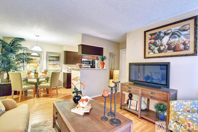 A living room with a television, a pineapple, and a painting on the wall.