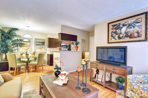 A living room with a television, a pineapple, and a painting on the wall.