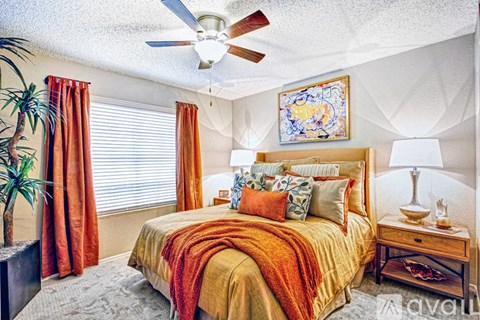 A bedroom with a bed, nightstand, and a ceiling fan.