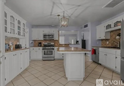 A kitchen with white cabinets and appliances.