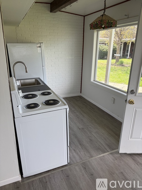 A kitchen with a white fridge and stove top oven.