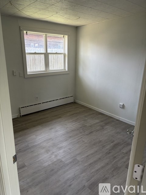 A room with a window and wooden flooring.