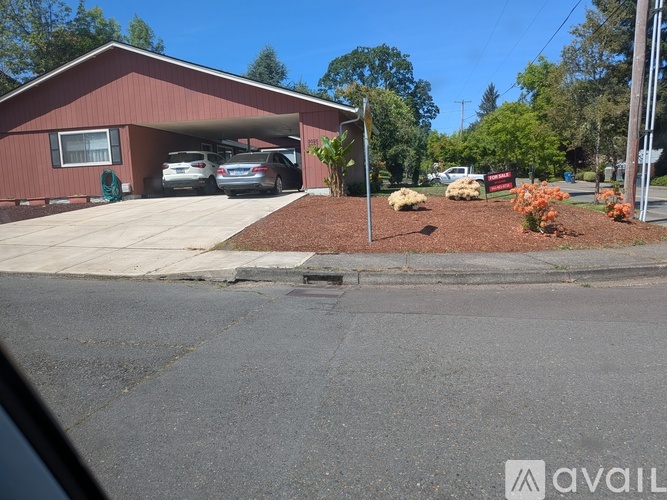 A red building with a garage door open and two cars inside.
