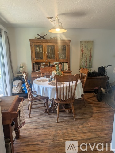 A dining room with a wooden table and chairs.